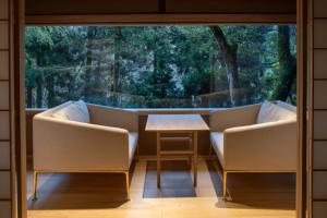 een kamer met 2 stoelen en een tafel voor een raam bij Tsukihitei in Nara