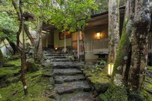 un camino de piedra que conduce a una casa con árboles en Tsukihitei, en Nara