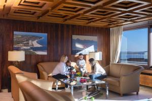 een groep mensen die rond een tafel in een woonkamer zitten bij Maritim Strandhotel Travemünde in Travemünde