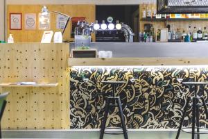 un bar avec un comptoir à motifs et des tabourets dans l'établissement ARTYSTER CLERMONT-FERRAND, à Clermont-Ferrand