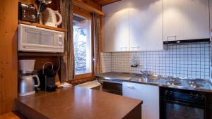 a kitchen with white cabinets and a counter top at Stachelbeere OG in Fiesch