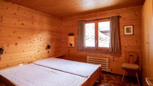 a bedroom with a bed in a wooden room at Stachelbeere OG in Fiesch