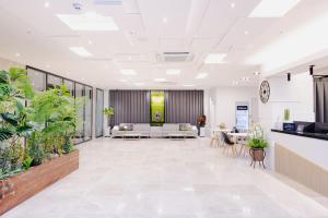 een kantoorlobby met witte meubels en potplanten bij Hotel Arari in Jeonju