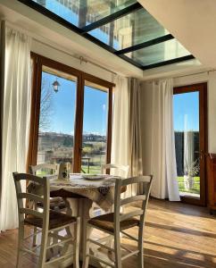 uma sala de jantar com mesa, cadeiras e janelas em Agriturismo La Corte del Sole em Siena