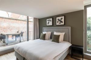 um quarto com uma cama grande e uma mesa em Dukes' Apartments Grand Place - by Dukes' Hotel Collection em Bruges