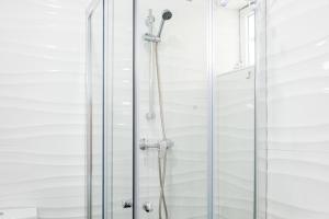 a shower with a glass door in a bathroom at Casa Fonte Nova in Nazaré