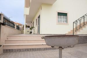 a stone planter in front of a white building at Casa Fonte Nova in Nazaré