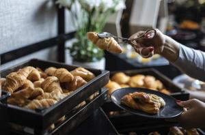 uma pessoa segurando um par de pinças sobre uma bandeja de doces em LUA Boutique RoomZ- Adults only em Balatonfüred