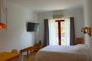 Habitación de hotel con cama y ventana en Sunrise Apartmento Ribeira d'Ilhas Ericeira, en Ericeira