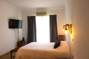 1 dormitorio con cama blanca y ventana en Sunrise Apartmento Ribeira d'Ilhas Ericeira, en Ericeira