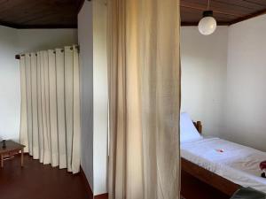 een slaapkamer met een bed en een raam met gordijnen bij WINGS HOTELS in Nosy Be