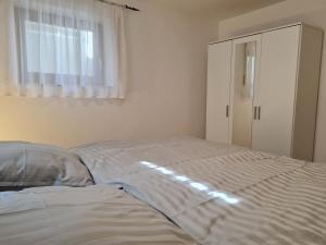 een wit bed in een slaapkamer met een raam bij Ferienwohnung Chrissi in Bischofsheim an der Rhön