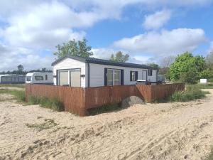 a tiny house on the beach next to a fence at Kite House Chałupy in Władysławowo