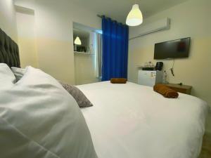 a large white bed in a room with a tv at The Castle Star in Amman