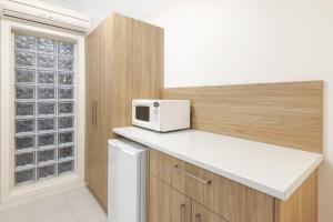 a kitchen with a white microwave and a window at Elizabethan Lodge in Melbourne