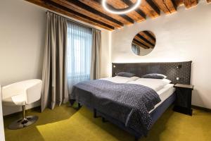 una camera con un grande letto e uno specchio di Boutiquehotel am Dom a Salisburgo