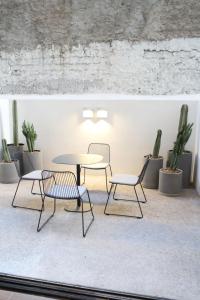 a table and chairs in a room with plants at Punto Panamericano in Guadalajara