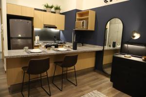 a kitchen with a counter with chairs and a refrigerator at Punto Panamericano in Guadalajara