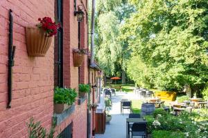 een bakstenen gebouw met potplanten en tafels en stoelen bij Boutique hotel Sies in Watervliet