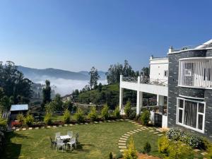 una casa con patio con mesa y sillas en Orchard Valley View Home Stay, en Ooty