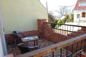 un patio con tavolo e sedie su un balcone in mattoni di Maya Guesthouse a Eger