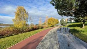 un camino sinuoso en un parque con árboles y un edificio en Gilužio Rivjera, en Vilna