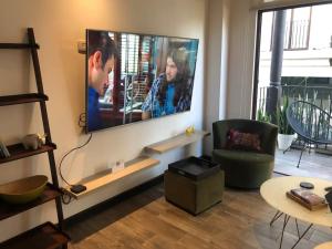 un soggiorno con una grande TV a schermo piatto a parete di L1B 202 - Boutique apartamento en Cayalá para 4 huéspedes a Guatemala