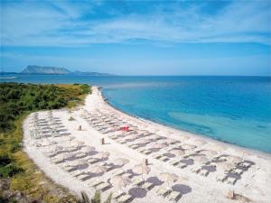 una playa con sillas y sombrillas y el océano en AMASEA Resort, en San Teodoro