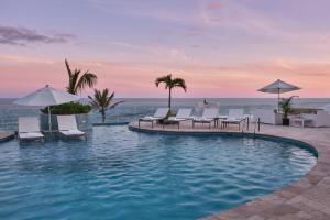 a pool at a resort with chairs and umbrellas at Azura Bermuda in Bermuda