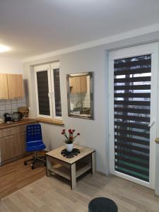 sala de estar con mesa y silla azul en Apartament przy dworcu, en Krosno