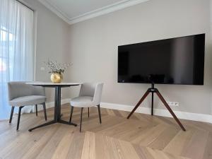 een woonkamer met een tafel en een groot scherm bij Luxury Home / 2-Raum-Apartment an der Frauenkirche in Dresden