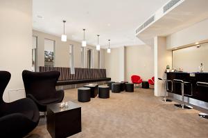 a salon with black chairs and red chairs at Newcastle Central Plaza Apartment Hotel Official in Newcastle