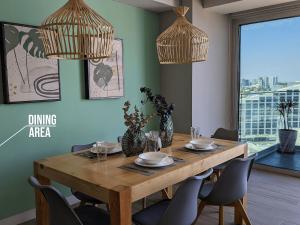 a dining area with a wooden table and chairs at Luxury Condo in Lobby33 near Andares By Bamboo in Guadalajara