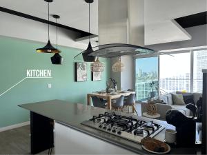 a kitchen with a stove top oven next to a living room at Luxury Condo in Lobby33 near Andares By Bamboo in Guadalajara