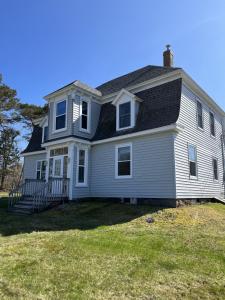 a white house with a black roof at Homeport Motel in Lunenburg