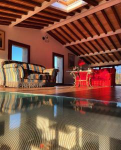 uma sala de estar com um sofá e uma piscina em Agriturismo La Corte del Sole em Siena