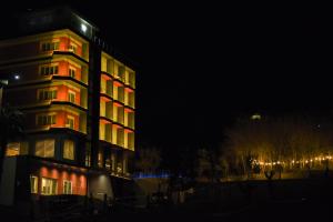 un palazzo alto con luci rosse di notte di Olivia's Hill Resort a Durrës