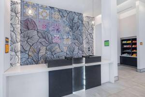 a lobby with a wall with a flower mural at La Quinta by Wyndham Chicago O'Hare Airport in Rosemont