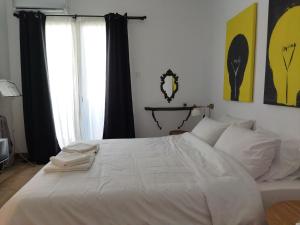 una camera con un letto bianco e una finestra di Minimal apartment by the beach a Korinthos