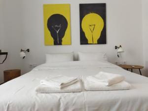 una camera da letto con un letto bianco con due asciugamani di Minimal apartment by the beach a Korinthos