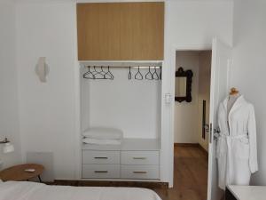 una camera bianca con letto e armadio di Minimal apartment by the beach a Korinthos