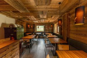 ein Esszimmer mit Holztischen und -stühlen in der Unterkunft Rifugio Lago Malghette in Madonna di Campiglio