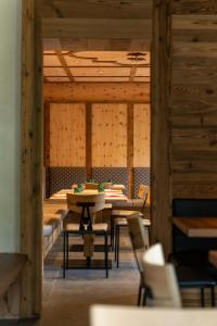 ein Esszimmer mit Tischen, Stühlen und Holzwänden in der Unterkunft Rifugio Lago Malghette in Madonna di Campiglio