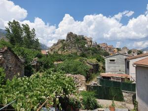 uitzicht op een dorp met een berg bij Maison Kyprea: charmant appartement /duplex , spacieux, tout confort avec terrasse extérieure privée, parking privatif , vue pittoresque sur la citadelle de Corté et les montagnes. in Corte