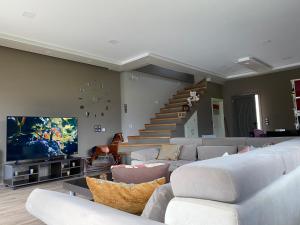 uma sala de estar com sofás e uma televisão e escadas em Villa Pamela em Përmet