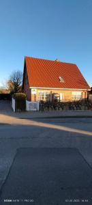 una casa con tetto arancione accanto a una strada di Privates Domizil auf Sylt in Strandnähe a Westerland