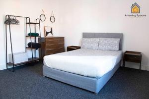 een slaapkamer met een bed en een dressoir en een bed sidx sidx bij Spacious 3 bed Terrace House with free parking & free Wi-Fi by Amazing Spaces Relocations Ltd in Saint Helens