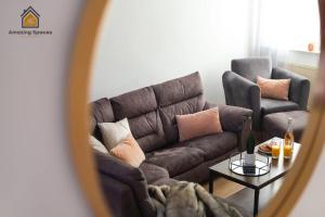 een woonkamer met een bruine bank en een tafel bij Spacious 3 bed Terrace House with free parking & free Wi-Fi by Amazing Spaces Relocations Ltd in Saint Helens