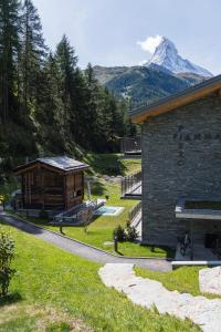 ein Blockhaus mit einem Berg im Hintergrund in der Unterkunft Piccola Fiamma by Pizzo Fiamma in Zermatt