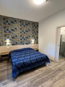 1 dormitorio con 1 cama con colcha azul en Hotel Anna Siena Nord, en Siena